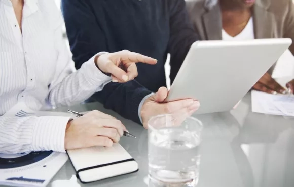Personnes discutant devant une tablette